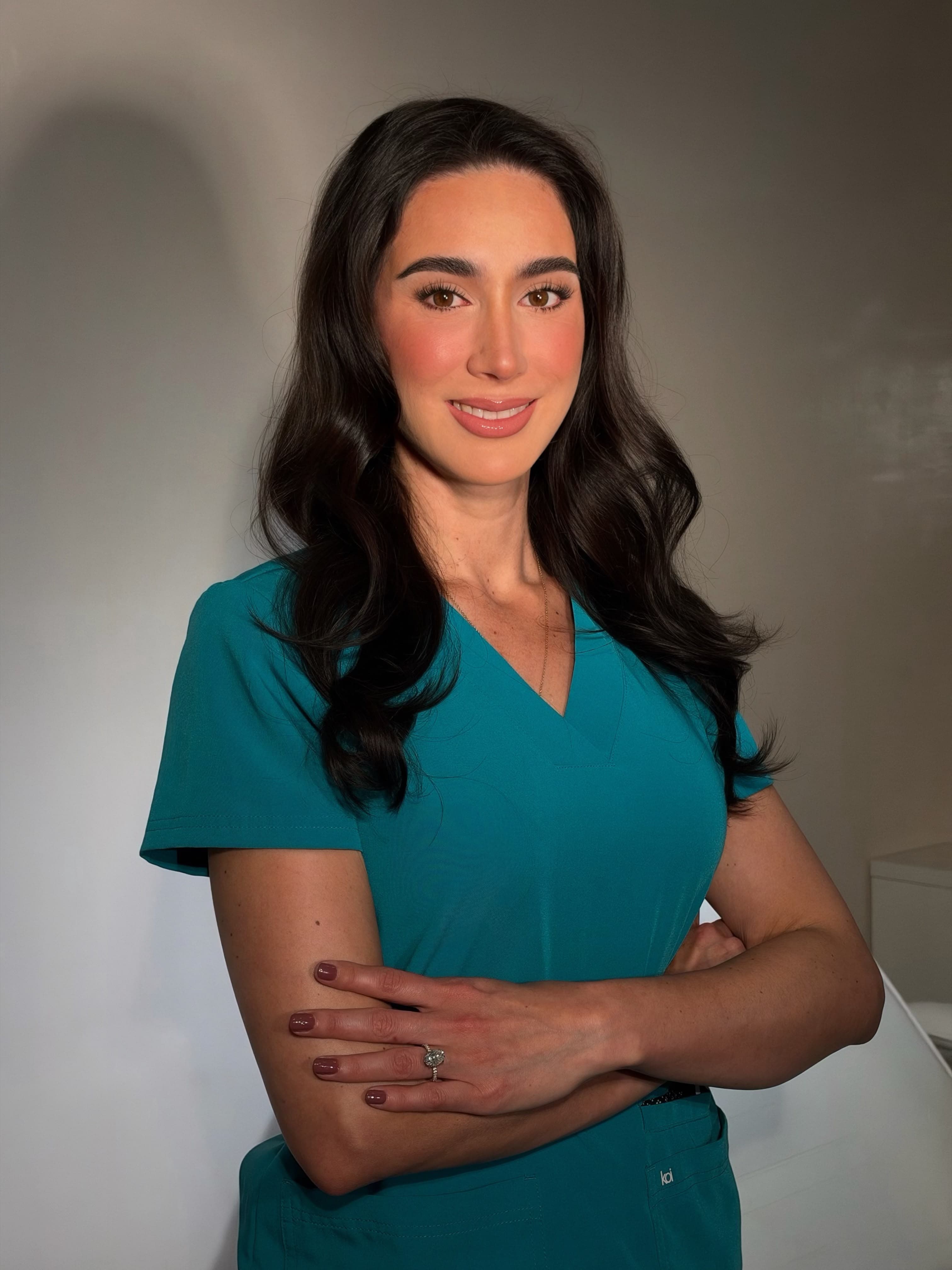 Dr. Marisol Gomez Martinez in teal medical scrubs.